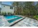 Secluded backyard pool surrounded by a tiled patio, mature trees, and a wrought-iron fence at 2415 Jasper Patterson Dr, Johns Island, SC 29455