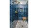 Walk-in shower with navy tile, stone pebble floor, and a built-in shower bench at 2415 Jasper Patterson Dr, Johns Island, SC 29455