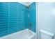 Modern shower with blue subway tiles, white grout, gold hardware, and white bathtub at 2415 Jasper Patterson Dr, Johns Island, SC 29455