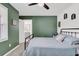 Serene bedroom with a ceiling fan, ensuite bathroom access, and a pleasant green accent wall at 303 Gippy Dr, Summerville, SC 29486