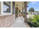 Covered front porch with two wooden rocking chairs, framed by brick columns and lush greenery at 303 Gippy Dr, Summerville, SC 29486