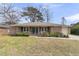 Charming brick home with a well-maintained front yard and a cozy front porch with rocking chairs at 303 Gippy Dr, Summerville, SC 29486
