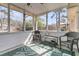 Screened porch featuring wicker furniture and a tropical-patterned rug at 303 Gippy Dr, Summerville, SC 29486