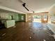 Living area with damaged hardwood floors, ceiling fans, and connected to the kitchen at 305 Sandridge Rd, Dorchester, SC 29437