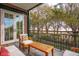 Inviting balcony with seating and views of the waterfront and trees visible through a black metal railing at 32 Prioleau St # N, Charleston, SC 29401