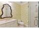 Charming bathroom with decorative wallpaper, framed mirror, glass door shower, and marble vanity at 32 Prioleau St # N, Charleston, SC 29401