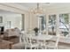 Elegant dining room with chandelier and waterfront views through large windows at 32 Prioleau St # N, Charleston, SC 29401