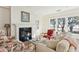 Bright living room with fireplace and large windows framing waterfront views and natural light at 32 Prioleau St # N, Charleston, SC 29401