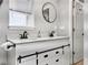 Bathroom boasts dual sinks, modern black fixtures, large round mirror, and plenty of counter space at 33 Athens Ct, Charleston, SC 29403