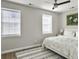 Bright bedroom featuring neutral walls, ceiling fan, wood floor, and plentiful natural light from two windows at 33 Athens Ct, Charleston, SC 29403