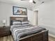 Comfortable bedroom featuring light gray walls, modern art piece, ceiling fan, night stand, and wood floor at 33 Athens Ct, Charleston, SC 29403