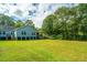 Large backyard featuring a two-story home with a porch and mature trees at 3596 Walter Drive Dr, Johns Island, SC 29455