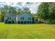 Large backyard featuring a two-story home with a porch at 3596 Walter Drive Dr, Johns Island, SC 29455