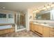 Bright bathroom featuring a large mirror, a walk-in shower, double sinks, stained glass windows, and a tub at 3596 Walter Drive Dr, Johns Island, SC 29455