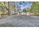 Wide open backyard with trees, shed, fire pit, covered back porch and lounge seating at 402 Corey Blvd, Summerville, SC 29483