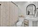 Bright bathroom featuring a pedestal sink, floral shower curtain, and a stylish arched mirror at 402 Corey Blvd, Summerville, SC 29483