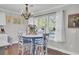 Cozy dining area featuring a round table, blue chairs, a charming chandelier, and bright window at 402 Corey Blvd, Summerville, SC 29483