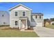 Charming two-story home with gray siding, white trim, manicured lawn, and attached two-car garage at 4171 Rising Tide Dr, Summerville, SC 29485