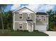 Two-story home featuring gray siding, white trim, a well-manicured lawn, and an attached two-car garage at 4171 Rising Tide Dr, Summerville, SC 29485