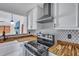 Updated kitchen featuring white cabinets, modern backsplash, and stainless-steel appliances with butcher block countertops at 425 Miami St # A, Ladson, SC 29456