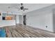 Open living room with hardwood floors, ceiling fan, neutral paint, and seamless transition to kitchen and hallway at 425 Miami St # A, Ladson, SC 29456