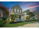 Charming two-story home featuring a cozy front porch, well-manicured lawn, and blooming flowers creating a welcoming curb appeal at 425 Verbena Ave, Summerville, SC 29483