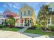 Inviting two-story home with a quaint front porch, a manicured lawn, and vibrant trees enhancing its curb appeal at 425 Verbena Ave, Summerville, SC 29483