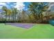 A tennis court with a net in a treed area and a bright blue sky with clouds above at 425 Verbena Ave, Summerville, SC 29483