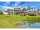 Expansive backyard view with well-manicured lawn, scenic pond, and cozy pergola for outdoor enjoyment at 436 Blue Elderberry, Moncks Corner, SC 29461