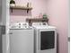 Well-organized laundry room featuring modern washer and dryer with overhead shelving for storage at 436 Blue Elderberry, Moncks Corner, SC 29461