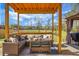 Outdoor seating under wooden pergola featuring a wicker sofa, table and decorative pillows at 436 Blue Elderberry, Moncks Corner, SC 29461