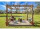Inviting outdoor pergola featuring a fire pit and seating with scenic pond views, perfect for relaxation and entertaining at 436 Blue Elderberry, Moncks Corner, SC 29461