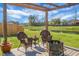 Outdoor pergola area featuring a fire pit, chairs, and views of a backyard pond at 436 Blue Elderberry, Moncks Corner, SC 29461