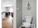 Cozy half-bathroom featuring a modern toilet, stylish decor, and a glimpse of the open-concept living and dining area at 436 Blue Elderberry, Moncks Corner, SC 29461