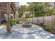 Inviting backyard featuring a stone fire pit, spacious patio, and a well-maintained fenced yard at 467 Nelliefield Trl, Wando, SC 29492