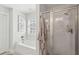 Bright bathroom featuring a tub and shower with glass doors, complemented by plantation shutters and light gray walls at 467 Nelliefield Trl, Wando, SC 29492