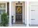 Elegant front door adorned with a wreath, flanked by columns, windows, and manicured greenery at 467 Nelliefield Trl, Wando, SC 29492