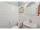 Stylish powder room featuring shiplap walls, a pedestal sink, and modern fixtures, offering a chic and functional space at 467 Nelliefield Trl, Wando, SC 29492