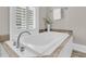 Relaxing bathroom featuring a deep soaking tub, hardwood trim and a large shuttered window at 4922 Sound View Dr, Mount Pleasant, SC 29466