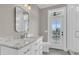 Bright bathroom featuring marble countertops, white cabinets, and a door that provides access to a private outdoor space at 4922 Sound View Dr, Mount Pleasant, SC 29466