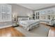 Bright bedroom featuring a plush bed, hardwood floors, and sun-drenched windows with stylish shutters at 4922 Sound View Dr, Mount Pleasant, SC 29466