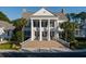 Gorgeous white clubhouse featuring stately columns and brick steps surrounded by luscious green landscaping at 4922 Sound View Dr, Mount Pleasant, SC 29466