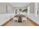 Spacious dining room with a rustic wooden table, white wainscoting, and a large jute rug at 4922 Sound View Dr, Mount Pleasant, SC 29466