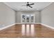 Spacious living room with hardwood floors, a ceiling fan, and access to a balcony via glass doors at 4922 Sound View Dr, Mount Pleasant, SC 29466