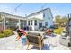Spacious backyard showcasing a stone patio with outdoor seating and screened-in porch at 523 Coaxum Rd, Mount Pleasant, SC 29464