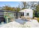 Charming backyard patio with a garden potting station, dining table with umbrella, and a convenient storage shed at 523 Coaxum Rd, Mount Pleasant, SC 29464