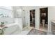 Bright bathroom features a modern tub, glass-enclosed shower, and access to walk-in closet, blending comfort and convenience at 523 Coaxum Rd, Mount Pleasant, SC 29464