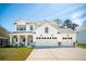 Charming two-story home with a three-car garage, stone accents, manicured lawn, and classic white siding at 523 Coaxum Rd, Mount Pleasant, SC 29464