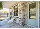 Inviting front porch with rocking chairs, stone details, and hanging plants, creating a welcoming outdoor space at 523 Coaxum Rd, Mount Pleasant, SC 29464
