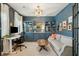 Comfortable home office with blue walls, custom shelving, and a cozy sitting area, perfect for productivity at 523 Coaxum Rd, Mount Pleasant, SC 29464